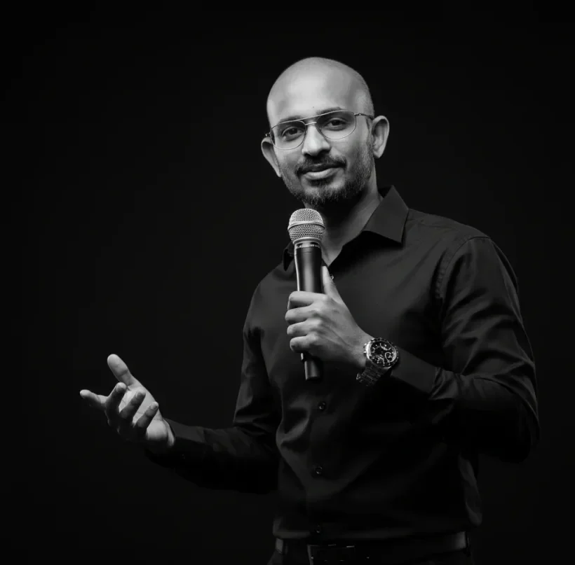 Zammy Zaif speaking into a handheld microphone, mid gesture