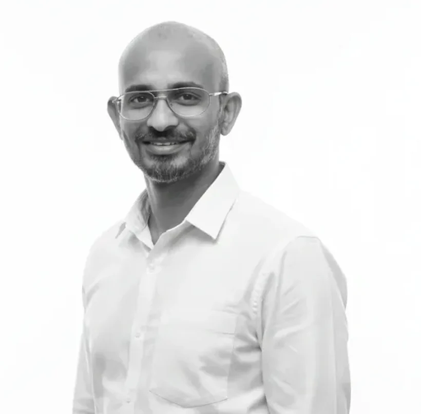 Zammy Zaif standing in a white shirt, turned slightly away from the camera